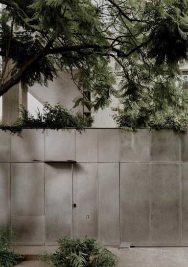 Una casa con un insolito basamento rivestito in acciaio inox. Che riflette l’immagine del contesto e attenua il confine tra architettura e paesaggio